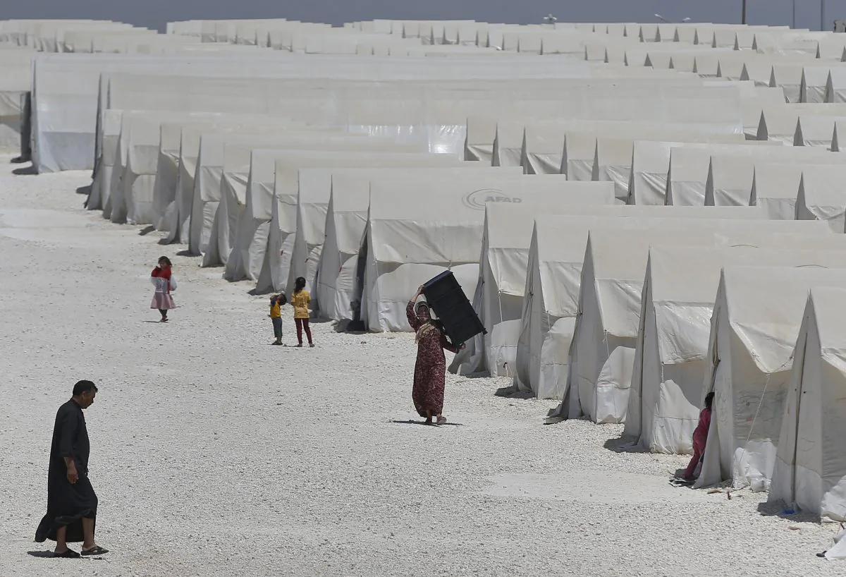Syrian refugees walk around a refugee camp in Suruc, on the Turkey-Syria border, on June 19, 2015. Ahead of World Refugee Day on Saturday, June 20, 2015, the U.N. refugee agency, UNHCR, estimated that a total of 11.6 million people from Syria had been displaced by the conflict by the end of last year, the largest such figure worldwide. Turkey is the world's biggest refugee host with 1.59 million refugees, according to the most recent U.N. figures. (AP Photo/Emrah Gurel)