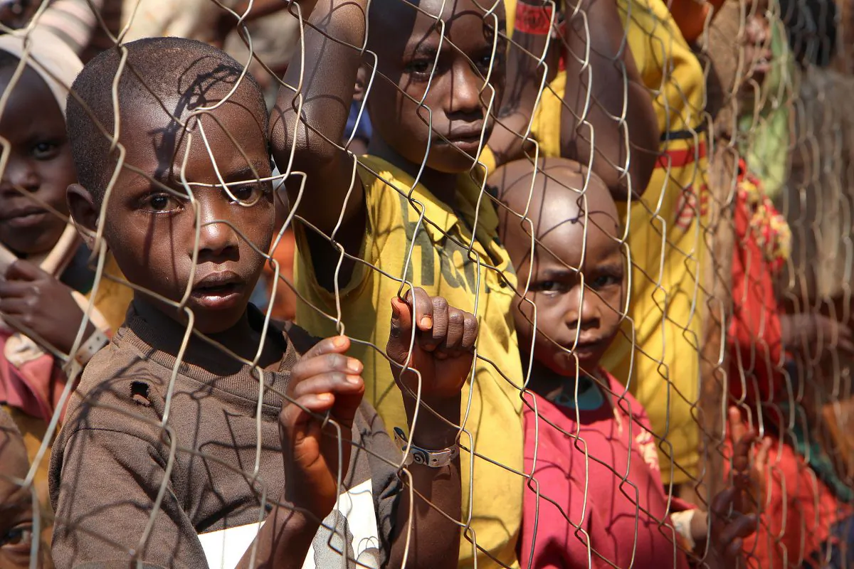Burundian children, who fled their country, stand behind a fence as they wait to be registered as refugees at Nyarugusu Camp, in northwestern Tanzania, on June 11, 2015. (Stephanie Aglietti/AFP/Getty Images)