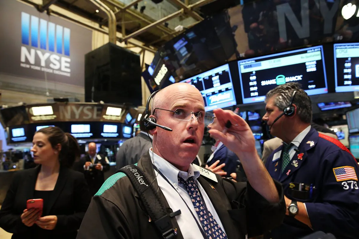 Traders wait for trading to resume on the floor of the New York Stock Exchange (NYSE) after trading was halted due to a "technical glitch" on July 8 in New York City. A cybersecurity firm is warning hackers may be probing the NYSE networks for a larger attack. (Spencer Platt/Getty Images)
