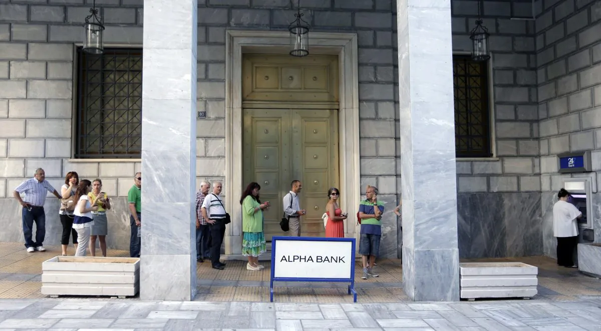 People stand in a queue to use the ATMs of a bank in Athens, Greece, Wednesday, July 8, 2015. (AP Photo/Petr David Josek)