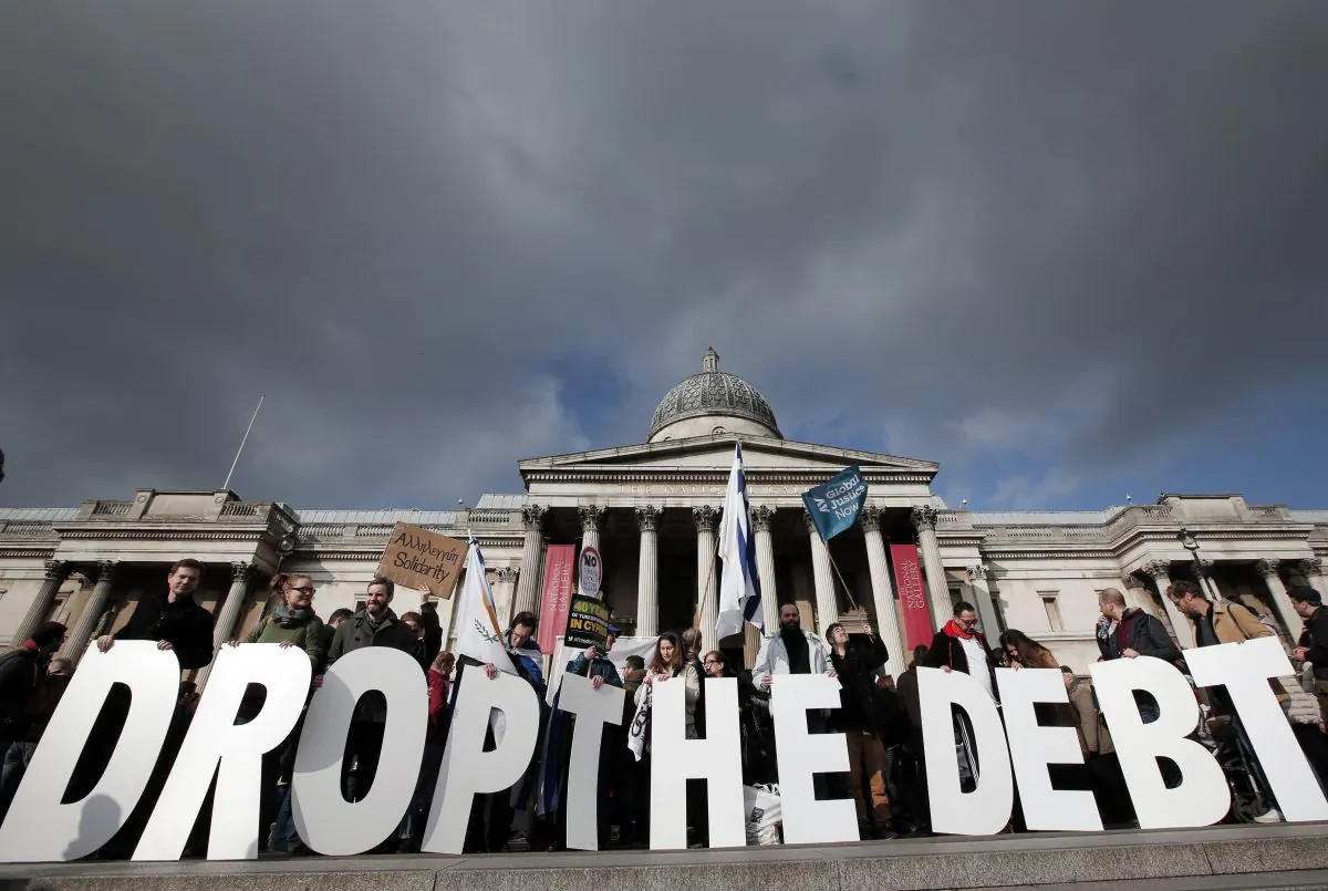 Protesters hold placards during a rally to show solidarity with Greece in central London, on Feb. 15, 2015. Hundreds of protesters gathered in support of the new government and the anti-austerity movement in Greece. (Lefteris Pitarakis/AP)