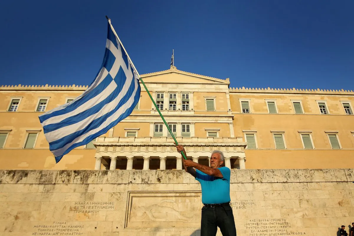 Athenians wave flags as they converge on Syntagma Square to show their support for the euro on July 9, 2015 in Athens, Greece. (Christopher Furlong/Getty Images)