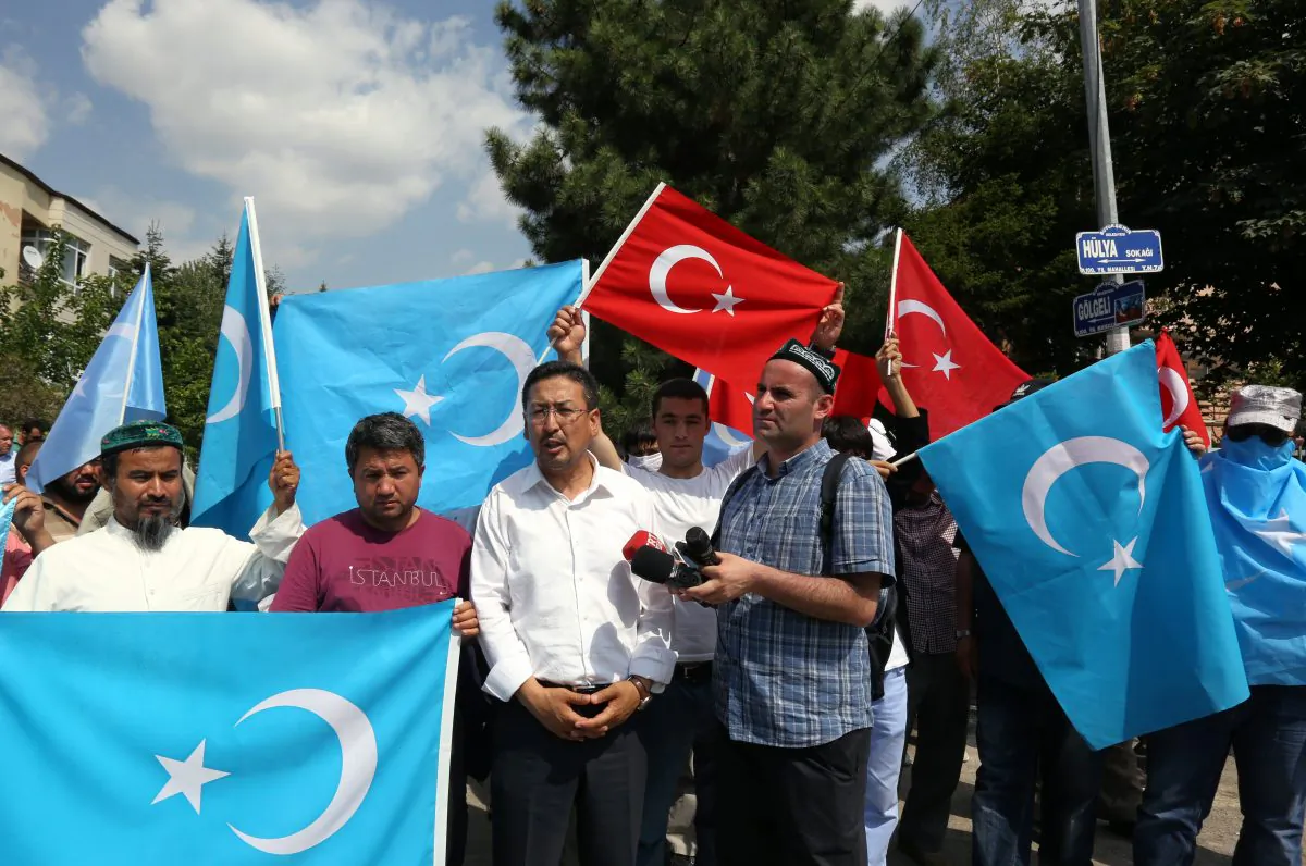 Uighurs demonstrate before the riot police used pepper spray to push back a group of Uighur protesters who tried to break through a barricade outside the Chinese Embassy in Ankara, Turkey, Thursday, June 9. 2015.   (AP Photo/Burhan Ozbilici)