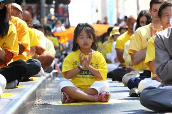 TINY MEDITATOR: A young Chinese girl meditates near Times Square on Saturday at a demonstration of the Falun Dafa exercises. (The Epoch Times) TINY MEDITATOR: A young Chinese girl meditates near Times Square on Saturday at a demonstration of the Falun Dafa exercises. (The Epoch Times)