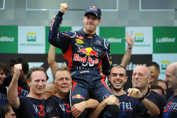 Sebastian Vettel (C) celebrates his third consecutive World Driving Championship with members of the Red Bull team, after the Formula One Brazilian Grand Prix on November 25, 2012. (Nelson Almeida/AFP/Getty Images)