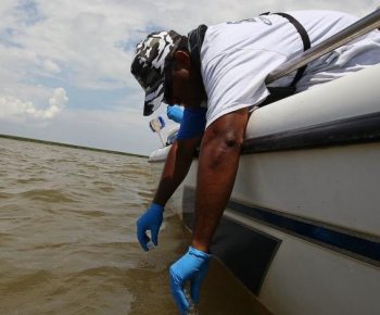 TESTING THE WATERS: Environmental Protection Agency contractor Larry Howard collects water samples for testing near the point where the South Pass of the Mississippi River meets the Gulf of Mexico in Louisiana. (Win McNamee/Getty Images)