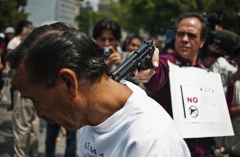 VIOLENT FORCE: Mexican journalists enact a murder during a protest against violence toward journalists in Mexico, on Aug. 7 in Mexico City. The protest was triggered by the abduction of four journalists by the Pacifico drug cartel to demand television stations to broadcast a video linking the Durango state government to a rival drug gang on July 26. (Ronaldo Schemidt/Getty Images) VIOLENT FORCE: Mexican journalists enact a murder during a protest against violence toward journalists in Mexico, on Aug. 7 in Mexico City. The protest was triggered by the abduction of four journalists by the Pacifico drug cartel to demand television stations to broadcast a video linking the Durango state government to a rival drug gang on July 26. (Ronaldo Schemidt/Getty Images)