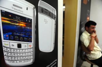 An Indian man speaks on his phone while sitting inside a BlackBerry phone store in Mumbai. BlackBerry manufacturer Research in Motion (RIM) continues to struggle with the Indian government's demand for full access to all data sent by the phones. (Indranil Mukherjee/Getty Images )