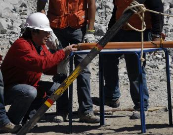 Chilean Minister of Mining Laurence Golborne (L) receives a 'dove', a rocket-shaped metal tube which is used to send supplies to the trapped miners, at the San Jose gold and copper mine in Copiapo, near Santiago on August 29.  (Ariel Marinkovic/Getty IMages)