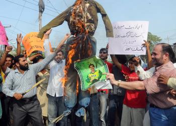 Pakistani cricket fans hold a burning effigy of national cricket team captain Salman Butt during a protest against a match fixing scandal, in Lahore on Aug. 31. (STR/AFP/Getty Images)