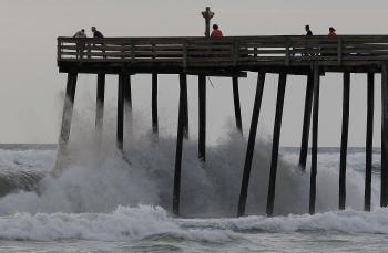 People stand on a pier as Hurricane Earl-induced waves crash below them in Southern Shores, N.C. on on Sept. 2. (Mark Wilson/Getty Images)
