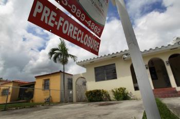 HOUSING WOES: A pre-foreclosure sign is seen in front of a home on Sep 16 in Miami, Fla. Weak housing prices is a major reason behind last quarter's $1.5 trillion decline in U.S. household wealth.
