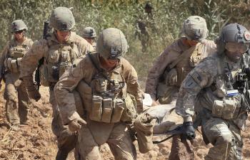 US Army flight medic SGT Tyrone Jordan (R) of Charlotte, NC of Dustoff Task Force Shadow of the 101st Combat Aviation Brigade helps Marines carry a wounded Afghani man to a MEDEVAC helicopter Sept. 29, 2010 near Marja, Afghanistan. (Scott Olson/Getty Images)
