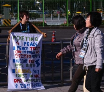 Thirteen year old Korean-American activist Jonathan Lee displays a poster outside the venue of the G20 Summit in Seoul on Nov. 12. Lee was detained at Tiananmen Square for unfurling a banner that said 'End the Korean War: sign a peace treaty,' in China. (Hoang Dinh Nam/Getty Images ) Thirteen year old Korean-American activist Jonathan Lee displays a poster outside the venue of the G20 Summit in Seoul on Nov. 12. Lee was detained at Tiananmen Square for unfurling a banner that said 'End the Korean War: sign a peace treaty,' in China. (Hoang Dinh Nam/Getty Images )