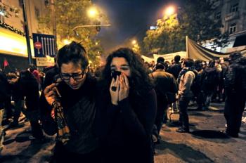 Demonstrators protect their faces from tear gas in the center of Athens on Dec. 6, 2010. (Aris MessInis/AFP/Getty Images)
