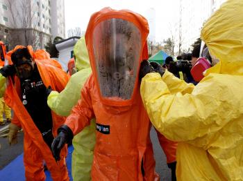 Emergency service personnel in chemical protection clothing participate in a civil defense exercise on December 15, 2010 in Paju, South Korea. (Chung Sung-Jun/Getty Images)