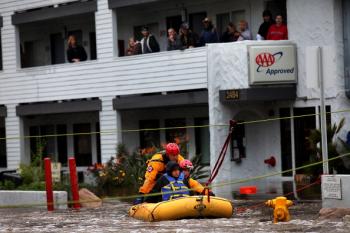 Danielle Broadnex, who is pregnant, is rescued from floodwaters after being stranded in a hotel, after a powerful rainstorm Dec. 22, 2010 in San Diego, California. (Sandy Huffaker/Getty Images)