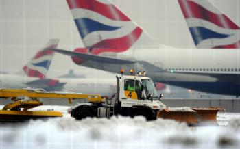 A worker operates a snow plough on Dec. 21 at London's Heathrow Airport, where passengers were forced to sleep on terminal floors during four days of chaos. (Adrian Dennis/AFP/Getty Images)