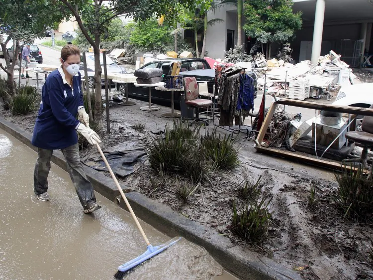 Volunteers help clean up the mess in the suburb of Milton on Jan. 15, 2011 in Brisbane, Australia. (Bradley Kanaris/Getty Images)