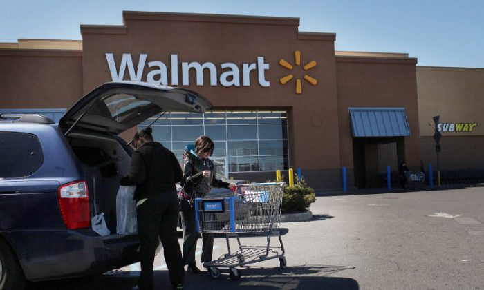 Shoppers put bags in a car at a Walmart store on March 29, 2011 in Valley Stream, New York. The company has been highly criticized for it adverse impacts on wages and small businesses. (Spencer Platt/Getty Images)