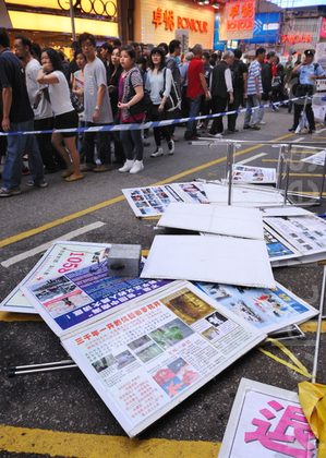 The thug tears down display frames, banners, and tables, Nov. 13, 2011. (Song Xiangling/Epoch Times)