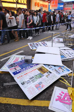 The thug tears down display frames, banners, and tables, Nov. 13, 2011. (Song Xiangling/Epoch Times)