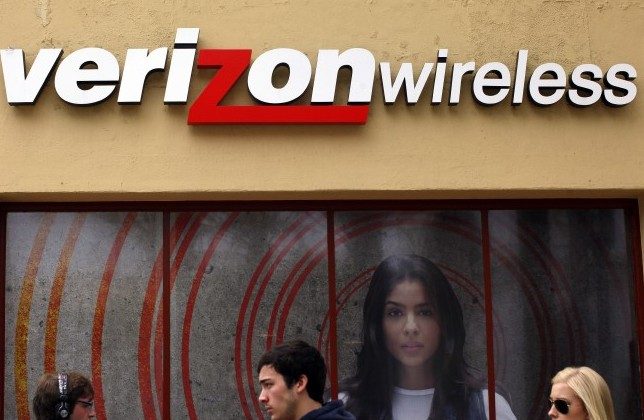 People walk past a Verizon store on April 21, 2011, in Los Angeles. Verizon has decided against charging a new fee after customer feedback. (ERIC THAYER/GETTY IMAGES)