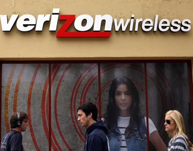 People walk past a Verizon store on April 21, 2011, in Los Angeles. Verizon has decided against charging a new fee after customer feedback. (ERIC THAYER/GETTY IMAGES)
