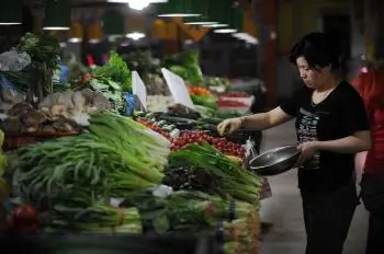 People shop for vegetables in a market in Beijing on May 11, 2011. The communist officials have their own safe food supply. (Peter Parks/AFP/Getty Images)