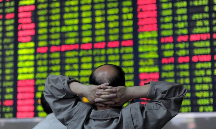 A Chinese investor checks share prices at a security firm in Hefei, east China's Anhui province on May 23, 2011. (STR/AFP/Getty Images)