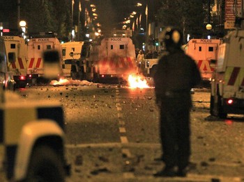 A policeman stands burning amid debris and police vehicles in east Belfast, Northern Ireland on June 21, 2011.  (Peter Muhly/AFP/Getty Images)