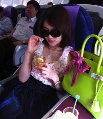 这张照片于 7 月 5 日在北京发布在互联网上，显示郭美美在飞行途中与她的众多名牌手袋中的一个合影。  （STR/法新社/盖蒂图片社）