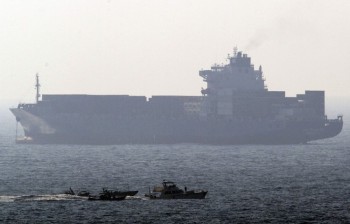 Backdropped by a cargo ship, the French yacht Dignite/Al Karama enters the Israeli southern port of Ashdod flanked by three small Israeli naval vessels on July 19.    (Jack Guez/Afp/Getty Images)