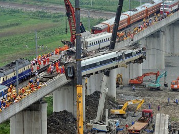 Workers clear wreckage of mangled carriages after a Chinese high-speed train derailed when it was hit from behind by another express late on July 23 in the town of Shuangyu near the city of Wenzhou, in eastern China's Zhejiang province. (AFP/Getty Images)