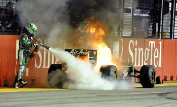 COOL UNDER FIRE: Finnish Formula 1 driver Heikki Kovalainen tries to extinguish his Lotus after it caught fire during the Formula 1 Singapore Grand Prix. (Bryan Van Der Beek/AFP/Getty Images) COOL UNDER FIRE: Finnish Formula 1 driver Heikki Kovalainen tries to extinguish his Lotus after it caught fire during the Formula 1 Singapore Grand Prix. (Bryan Van Der Beek/AFP/Getty Images)