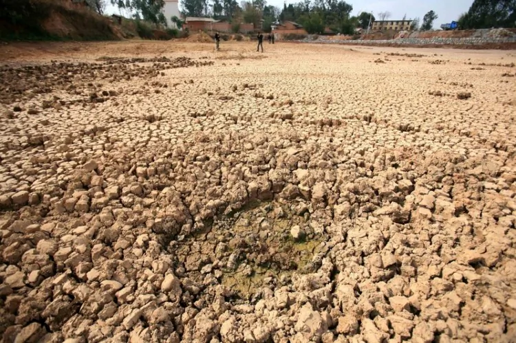 Chinese villagers walk by a dried up field in Yiliang, southwest China's Yunnan province on February 27, 2012. A drought in Yunnan province has left 3.19 million people and 1.58 million livestock short of drinking water, the provincial government said, as drought and low rainfall in the three consecutive years have dried up 273 rivers and 413 small reservoirs in the province. (STR/AFP/Getty Images)