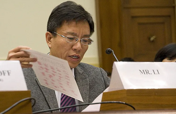 Li Hai holds up a copy of a document from China signed with the thumbprints of villagers, petitioning for the release of a detained Falun Gong practitioner. (The Epoch Times)