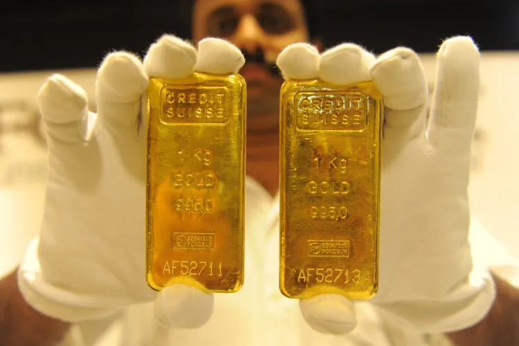 In this undated file photo, a jewelry shop employee displays 24-carat gold bars in India. Gold prices increased 1.2 percent on Dec. 31, 2012. (Sam Panthaky/AFP/Getty Images)