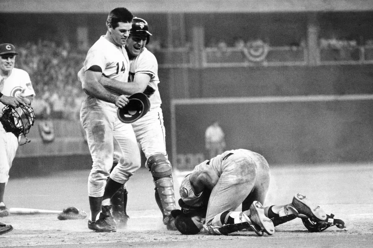 Pete Rose (L) is hugged by teammate Dick Dietz after scoring the winning run while running over  catcher Ray Fosse (R), who suffered a separated shoulder on the play. (AP Photo) 