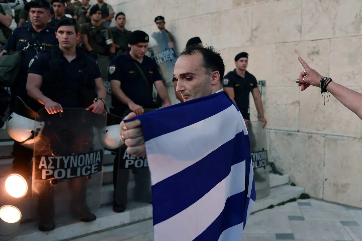 A man wrapped in a greek flag stands in front of  the stairs leading to the Greek parliament in Athens during an  anti-EU demonstration in Athens calling for a 'NO' to any agreement with the creditors on July 13, 2015. (Louisa Gouliamaki/AFP/Getty Images)