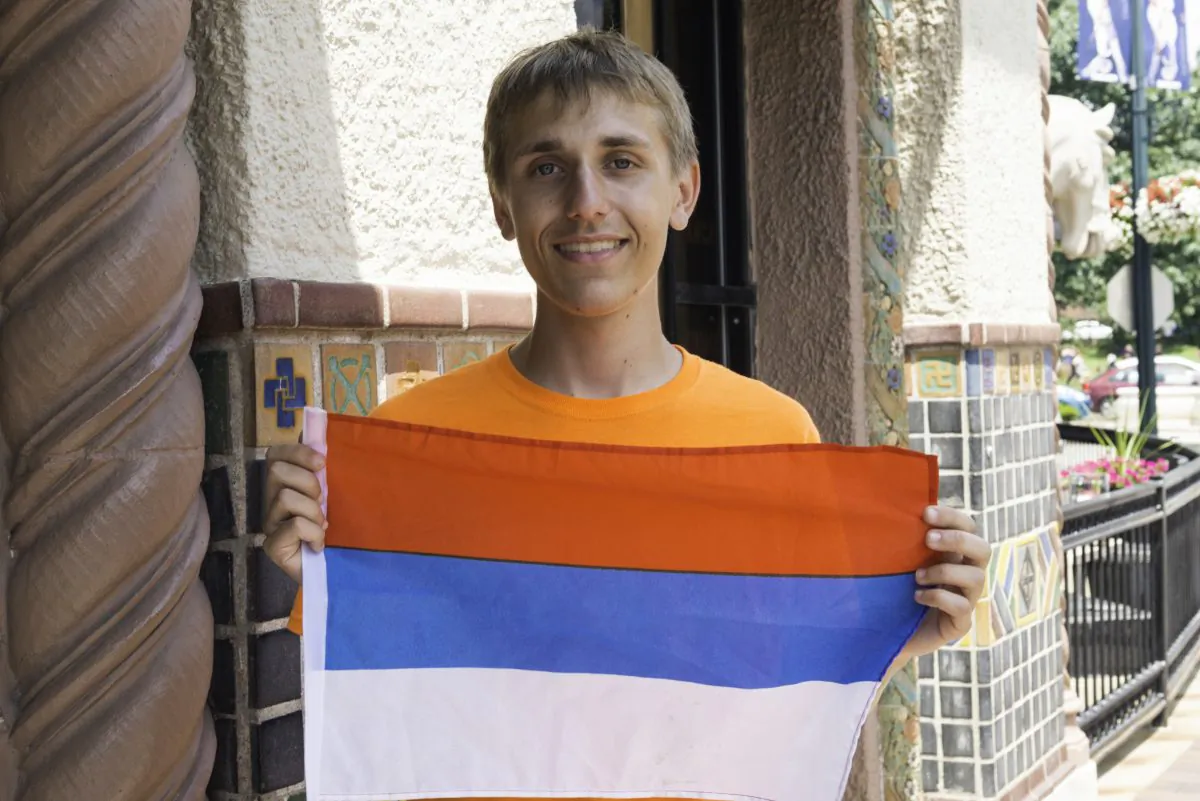 Nikita Kraiouchkine holds a Russian flag at a rally in Kansas City, Missouri on June 27, 2015. (Cat Rooney/Epoch Times)