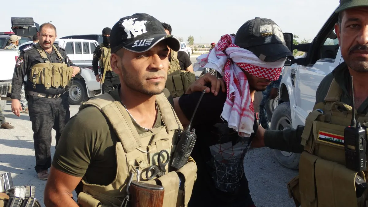 Iraqi security forces arrest a suspect accused of being a militant of the Islamic State group, at a refugee camp in Amiriyat al-Fallujah, a town south of Fallujah in Anbar province, west of Baghdad, Iraq, Thursday, June 18, 2015. (AP Photo)