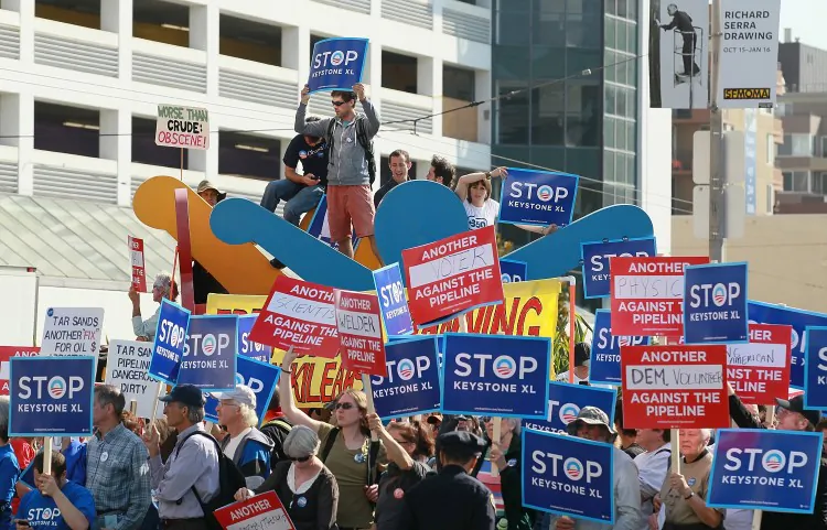 Protesters of the Keystone XL oil pipeline hold signs and demonstrate outside of the W Hotel before the arrival of President Barack Obama on Oct. 25 in San Francisco, Calif. The decision to delay the project was hailed as a major victory for environmental groups. (Justin Sullivan/Getty Images)