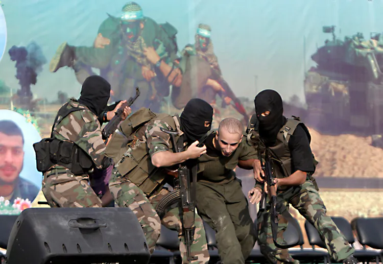 Palestinian militants with the Ezzedine Al-Qassam Brigades, the armed wing of the Islamist movement Hamas, simulate the kidnapping of Israeli soldier on Oct. 28. Hamas recently declared that computer hacking is the “new field of resistance.” (Said Khatib/Getty Images)
