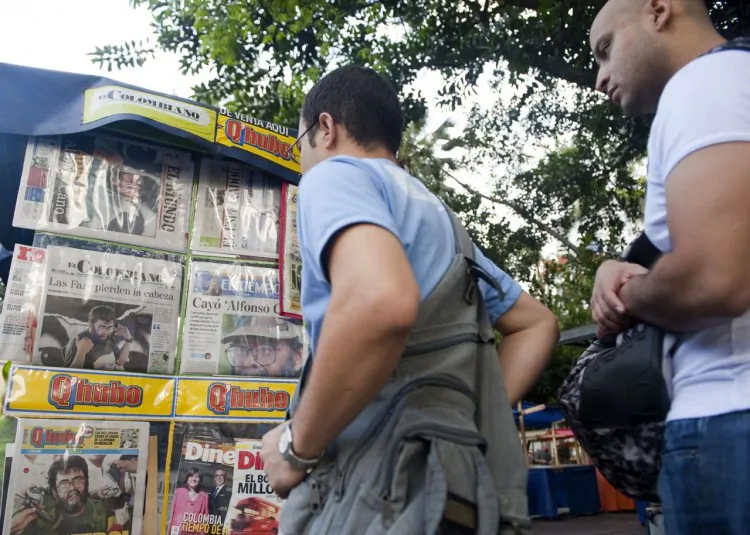 Passers-by look at newspapers reporting on the death of the leader of the Revolutionary Armed Forces of Colombia (FARC), Alfonso Cano, at a newsstand in Medellin, Antioquia department, on Nov.r 5, 2011. (Raul Arboleda/AFP/Getty Images)