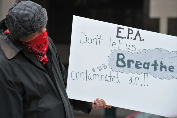 A demonstrator with the No FEAR Coalition, the National Whistleblower Center, and the Federal Alliance, holds a placard during a protest Nov. 10, 2011 at the Environmental Protection Agency in Washington, D.C. To date there are more than three dozen lawsuits in the Washington courts seeking to derail the EPA’s Interstate Air Pollution Rule. (KAREN BLEIER/AFP/Getty Images)