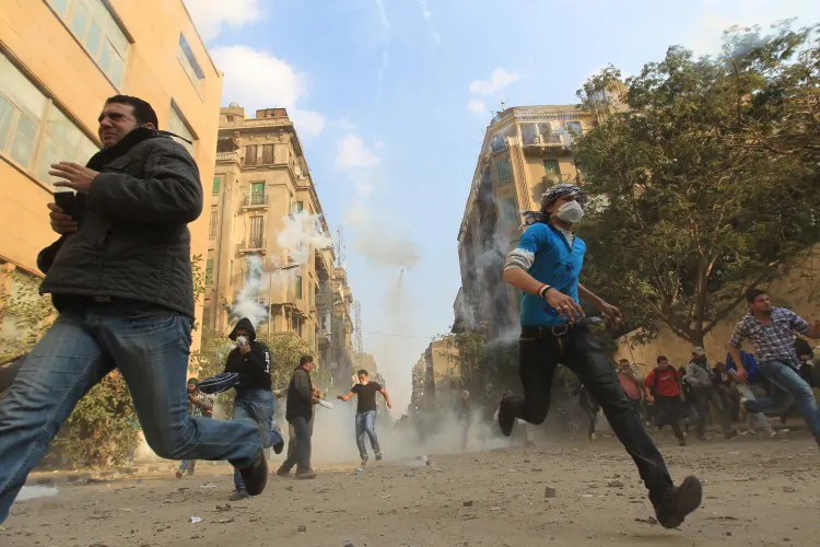 Egyptian protesters run for cover on the third day of clashes with security forces at Tahrir Square in Cairo on November 21, 2011. (Khaled Desouki/AFP/Getty Images)