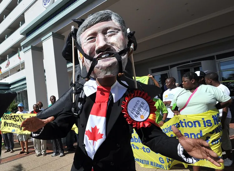 An activist wears a mask depicting the face of Canadian Prime Minister, Stephen Harper, during a protest in Durban on the sidelines of the UN climate talks, on December 5. (Alexander Joe/Getty Images)