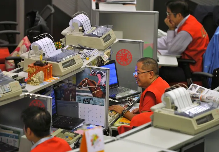 Traders sit at their desks at the Hong Kong Stock Exchange (HKEx), Dec. 15. Beginning March 5, HKEx traders had their lunch breaks shortened in an effort to boost trading volume and allow HKEx to compete with regional and global peers. (Aaron Tam/AFP/Getty Images)