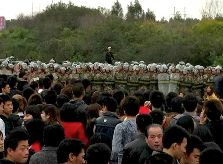 Chinese residents confront riot police as they protest along a highway to demand a coal-fired plant be moved, in Haimen Township in southern China’s Guangdong Province on Dec. 20, 2011. Mass protests in China are a daily occurrence. (STR/AFP/Getty Images)